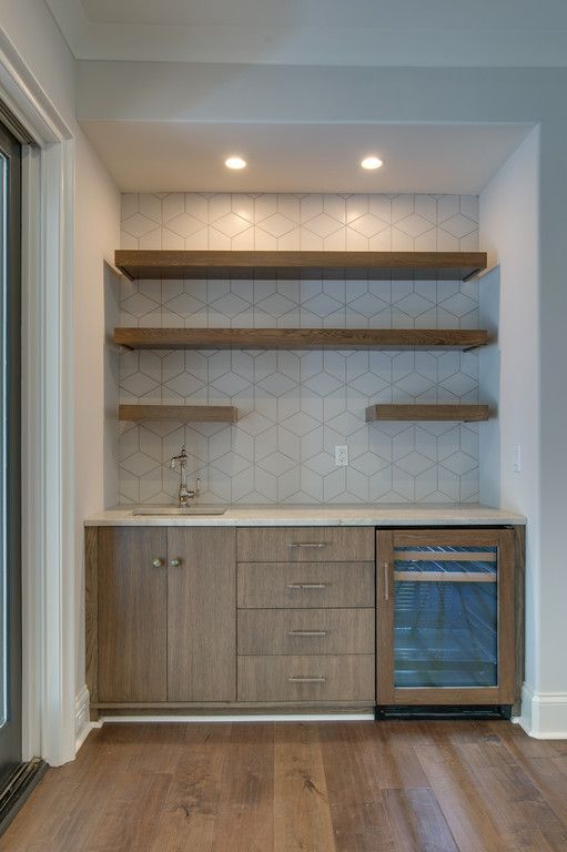 A kitchen with wooden cabinets , shelves , a sink and a refrigerator.