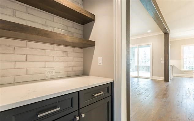 A kitchen with a bar and a brick wall.