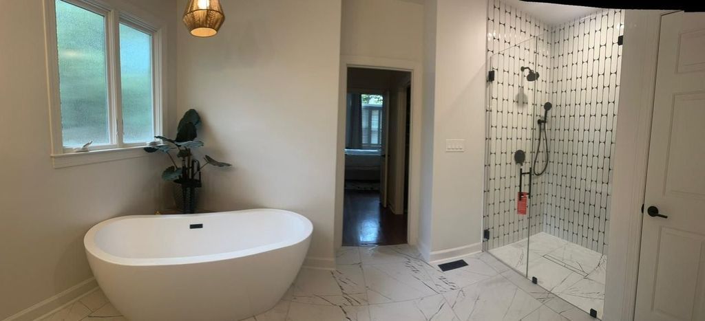 A bathroom with a bathtub and a walk in shower.