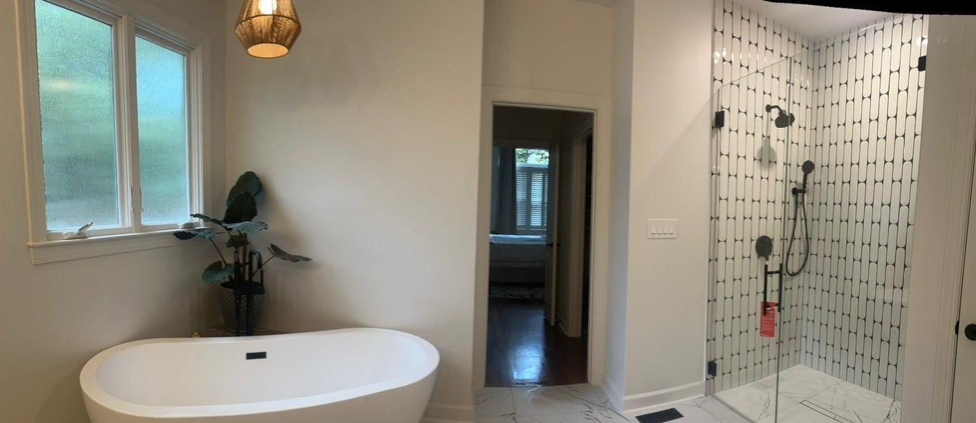 A bathroom with a tub , shower , and window.