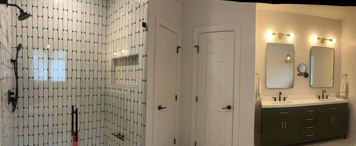 A bathroom with a walk in shower and two sinks.