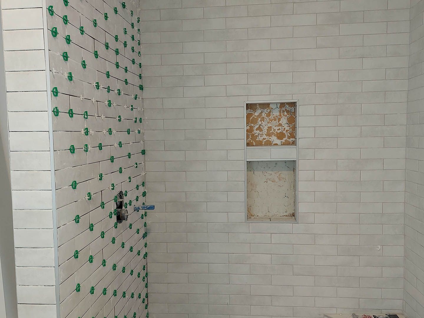 A bathroom with a brick wall and a niche in the wall.