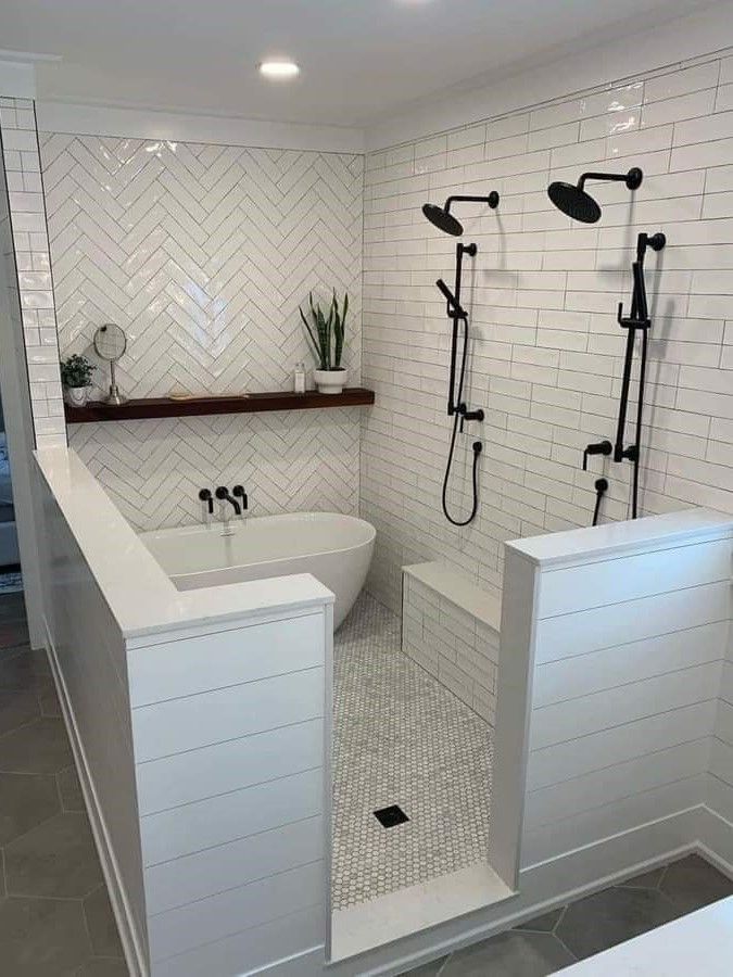 A bathroom with two showers and a bathtub.