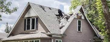 A house with a roof that has been damaged by a storm.