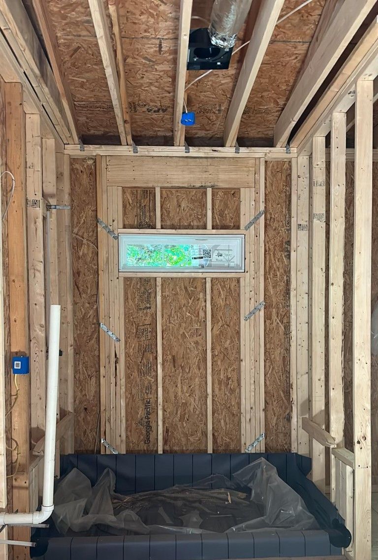 A bathroom in a house under construction with a bathtub.