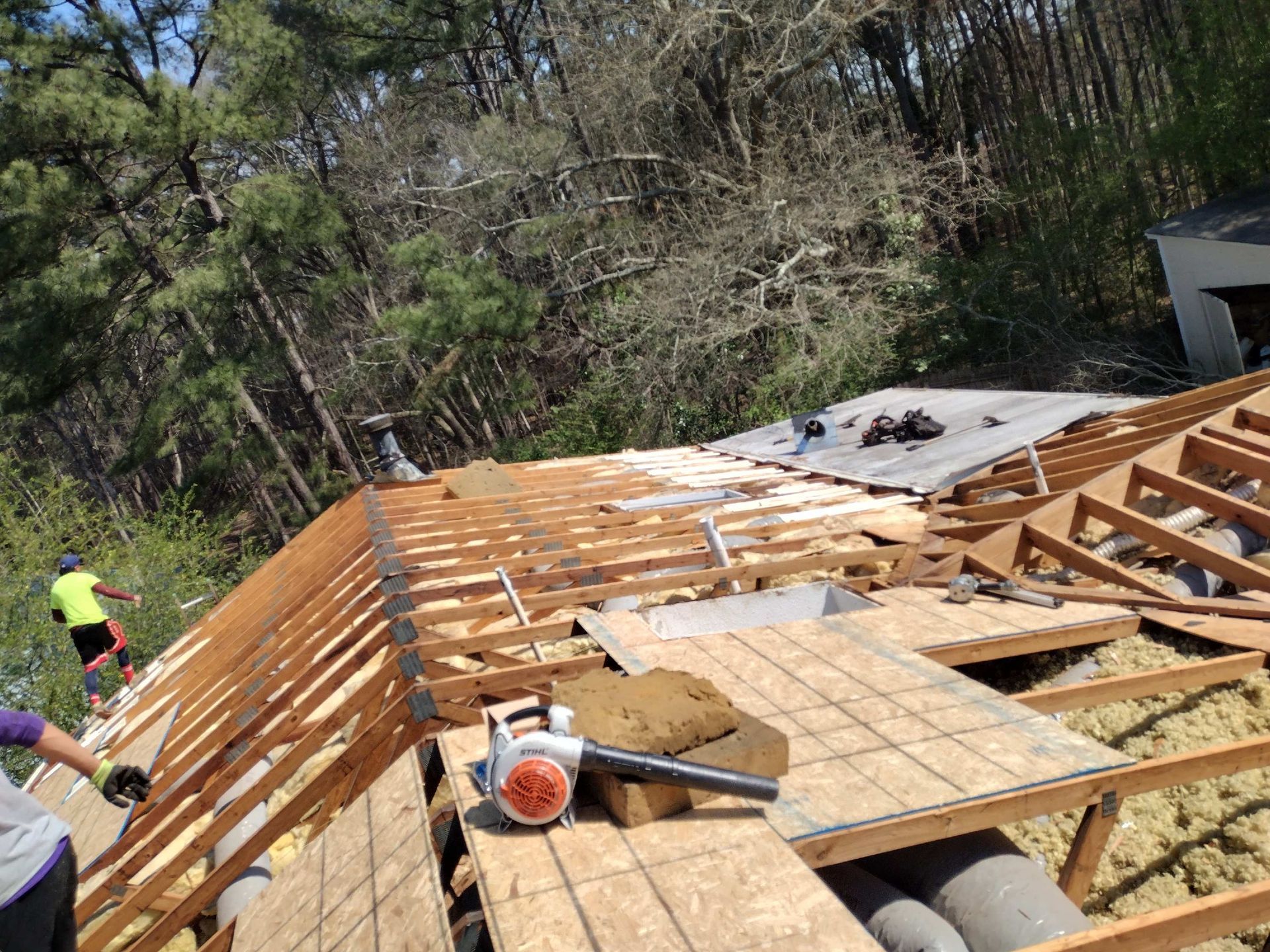A blower is sitting on top of a wooden roof.