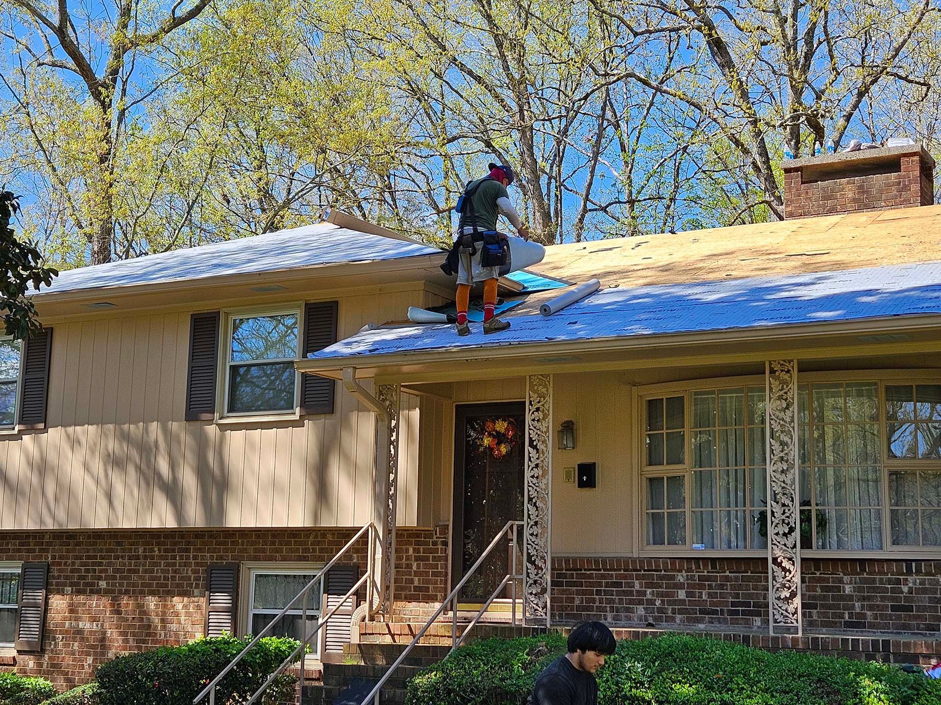A man is working on the roof of a house.