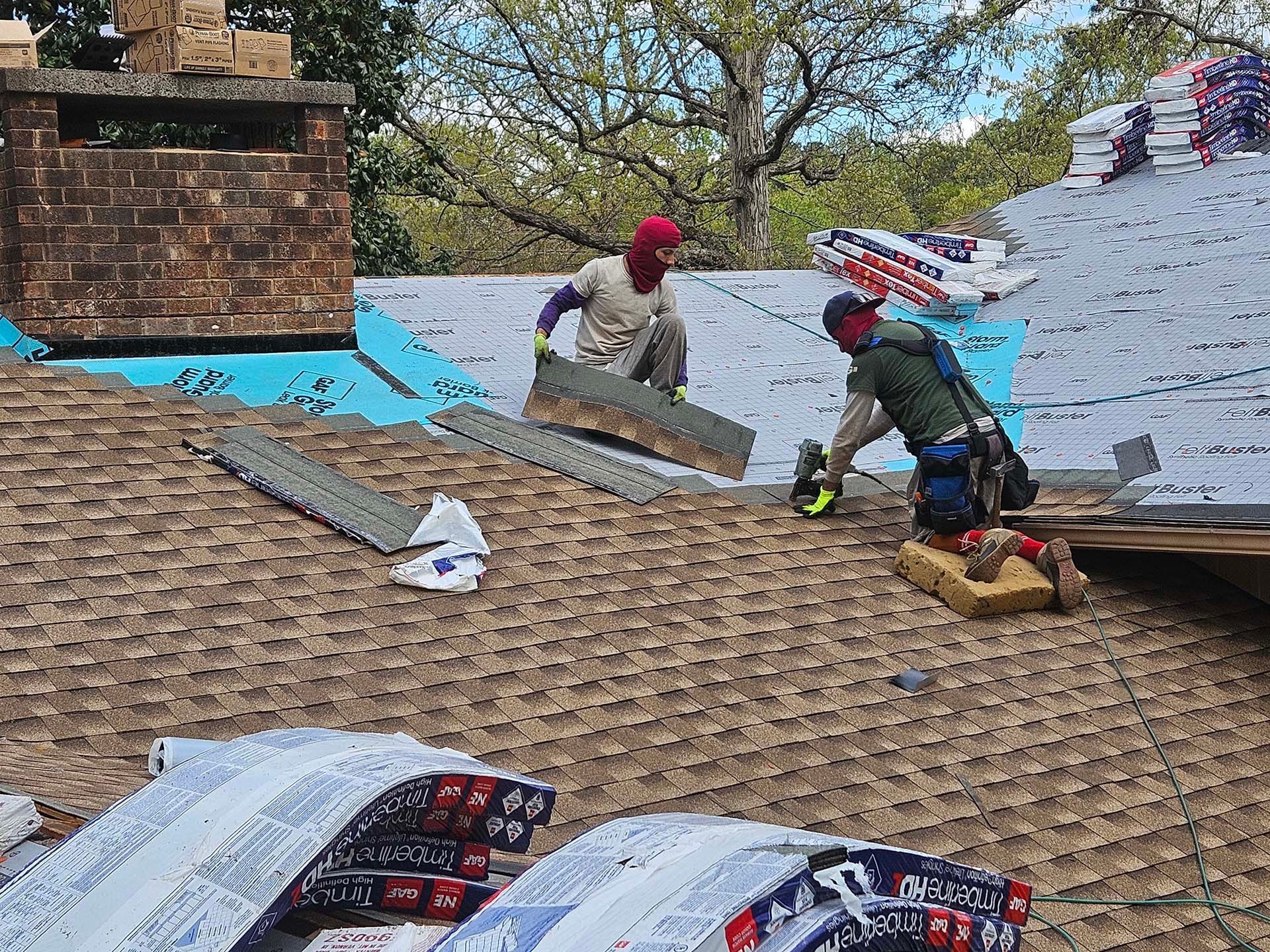 Two men are working on the roof of a house.