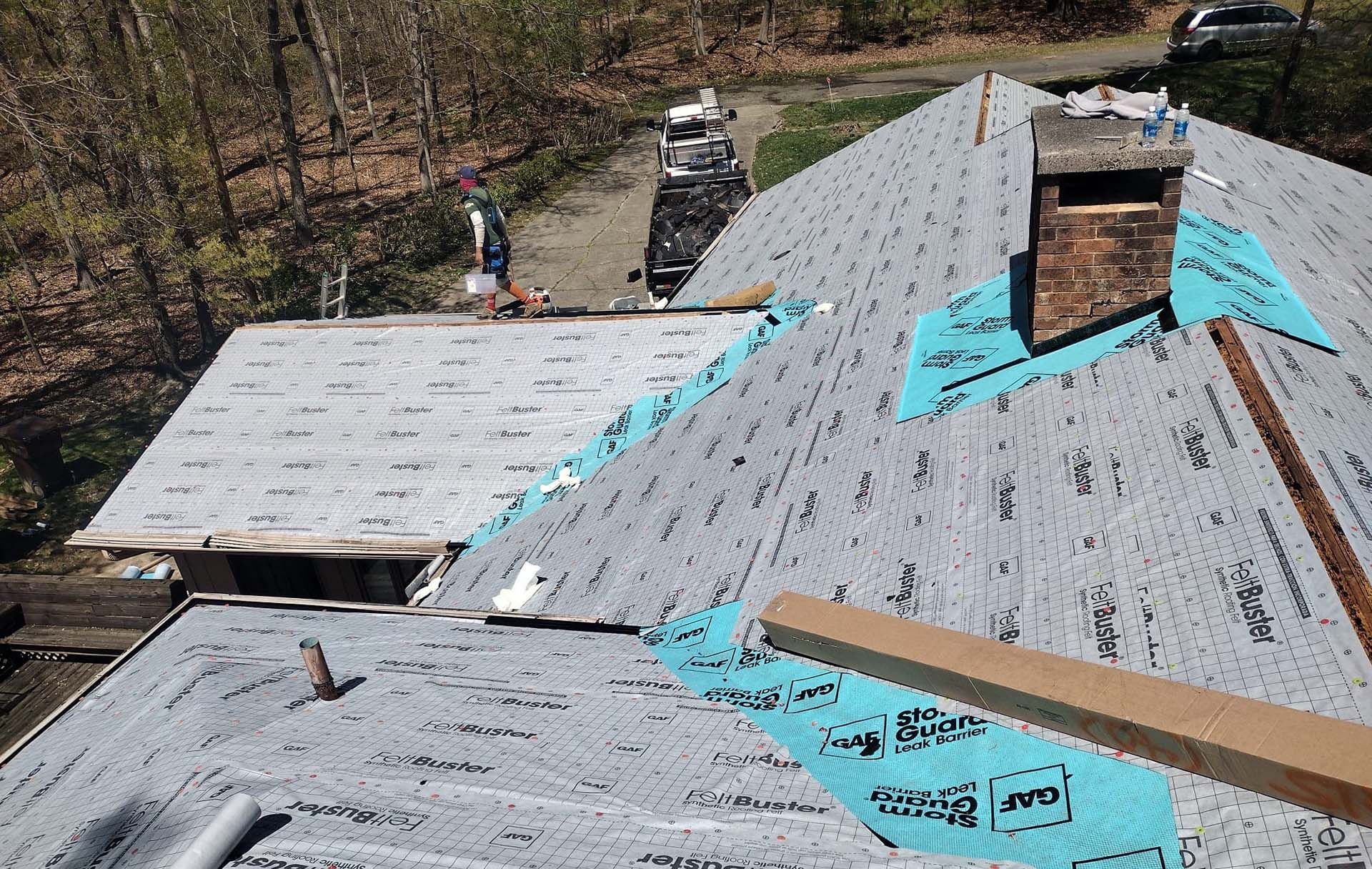 A roof is being installed on a house with a chimney.