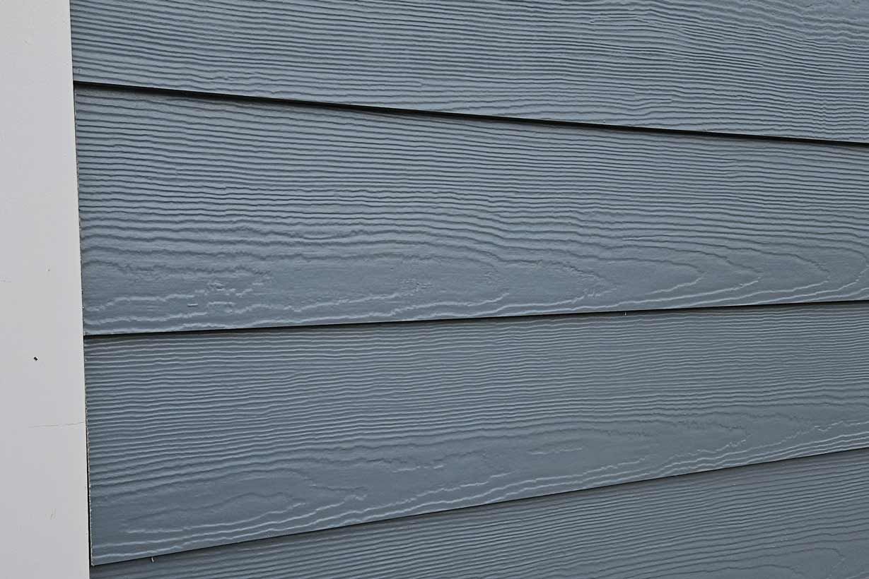 A close up of a blue siding on a house.