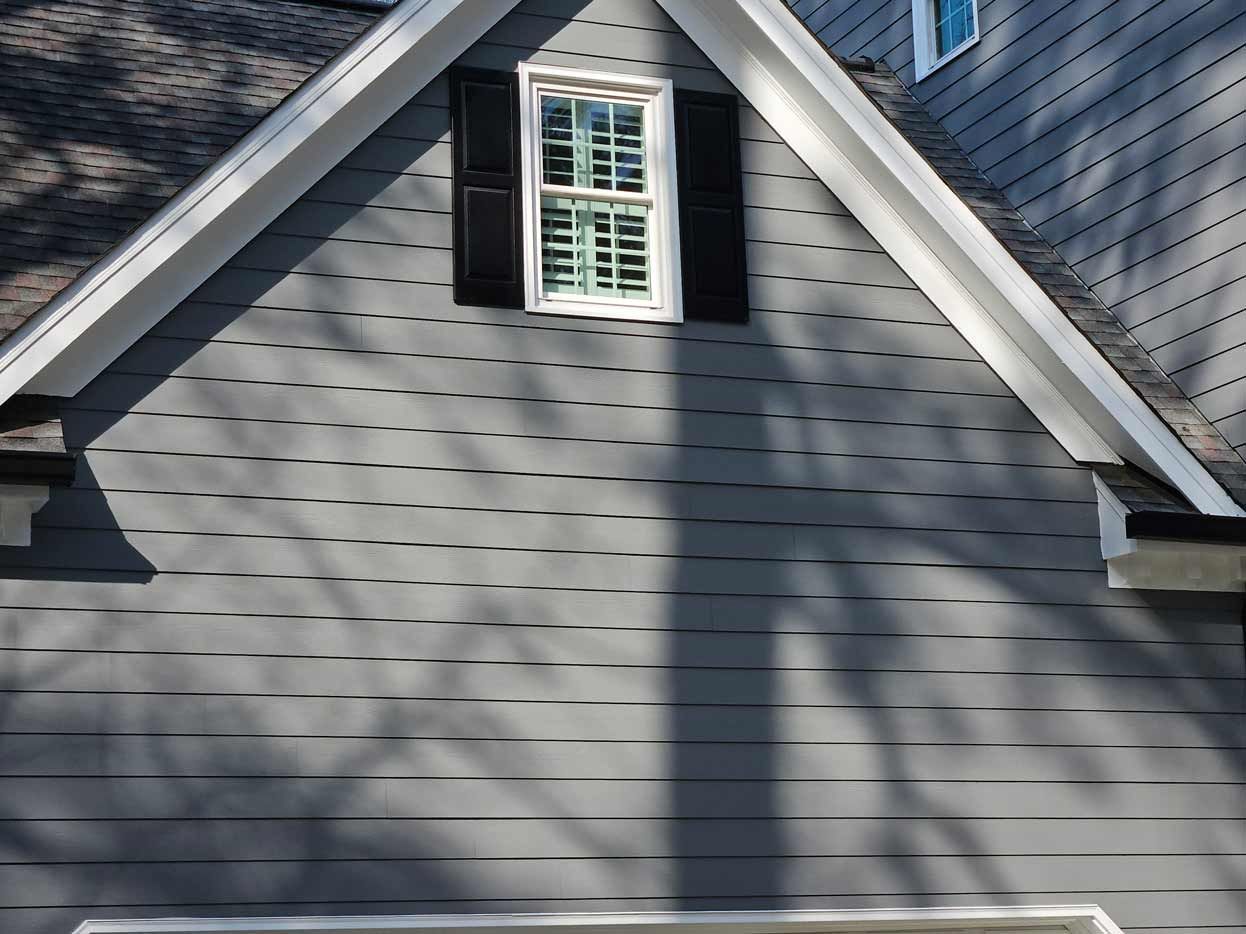 The roof of a house with a window and shutters