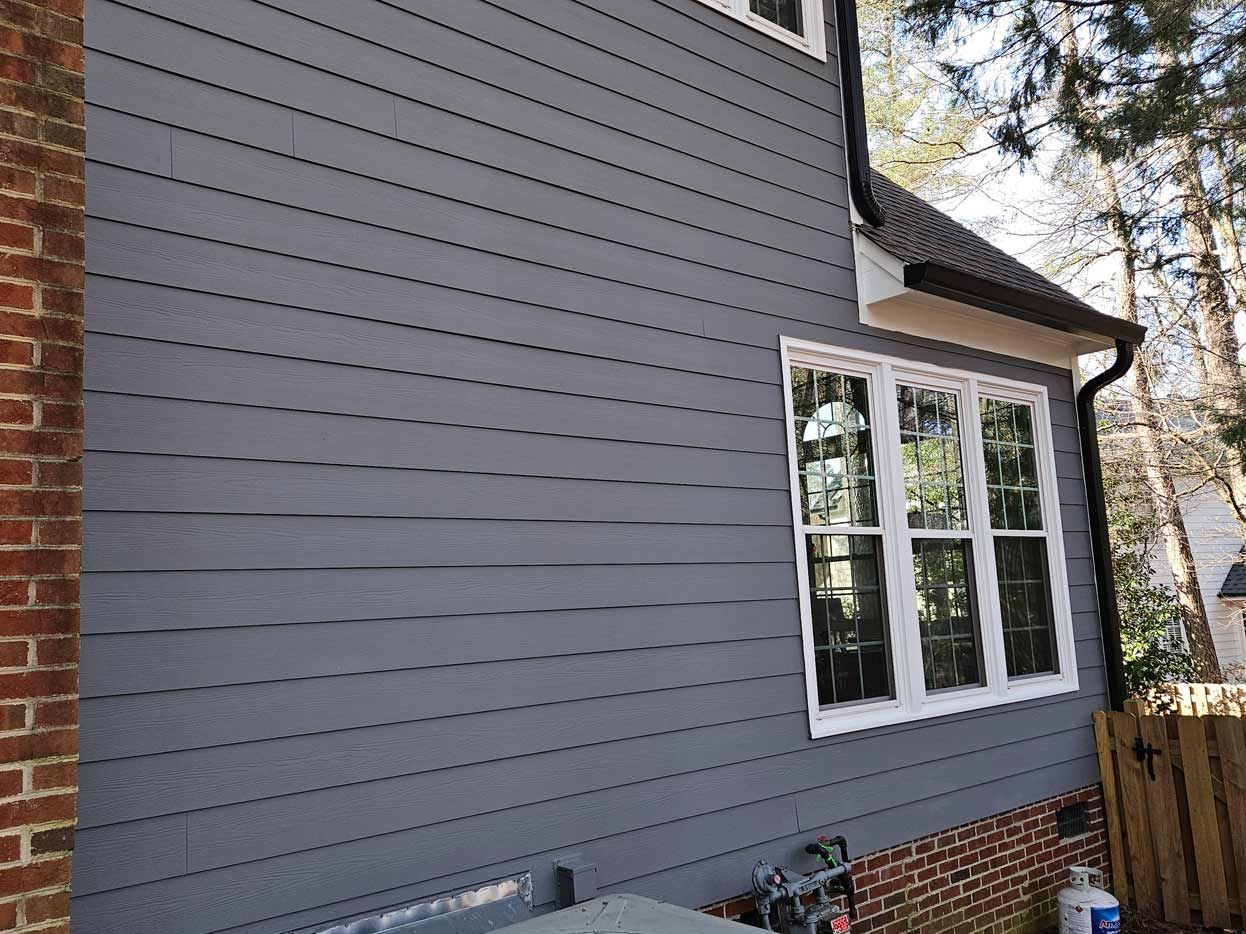 A house with a gray siding and white windows