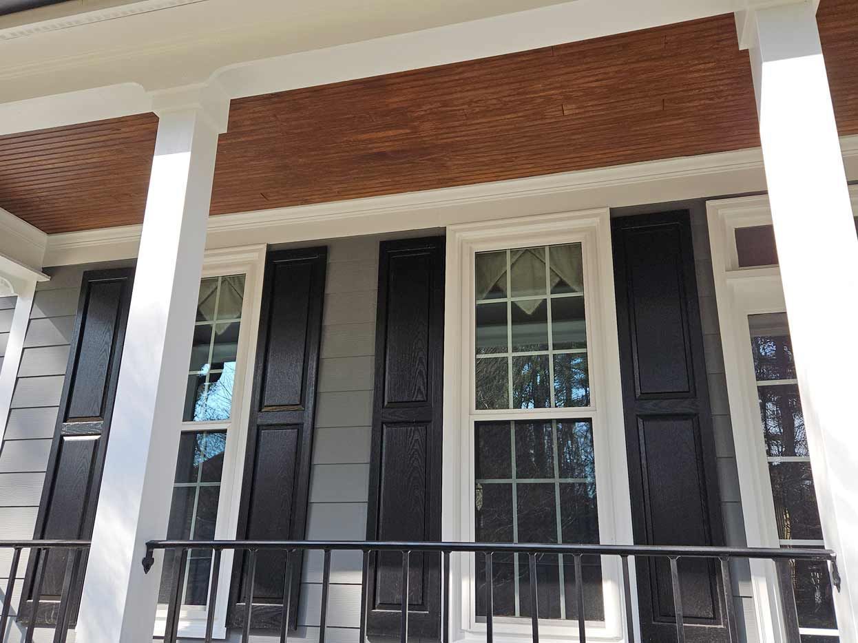 The front of a house with black shutters and white trim.