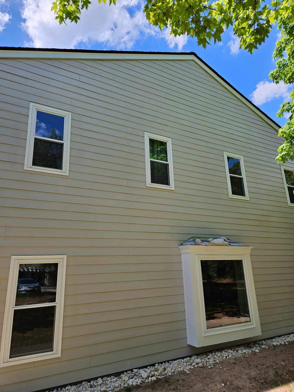 A large house with a lot of windows and a blue sky in the background.