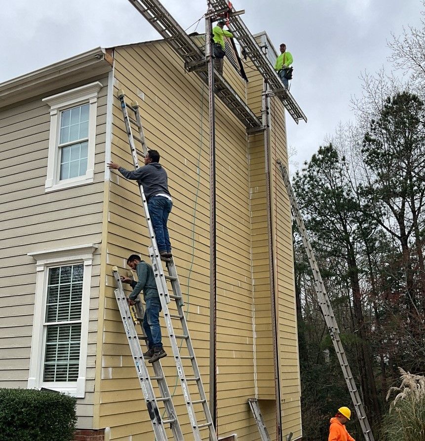 A group of men are working on the side of a house