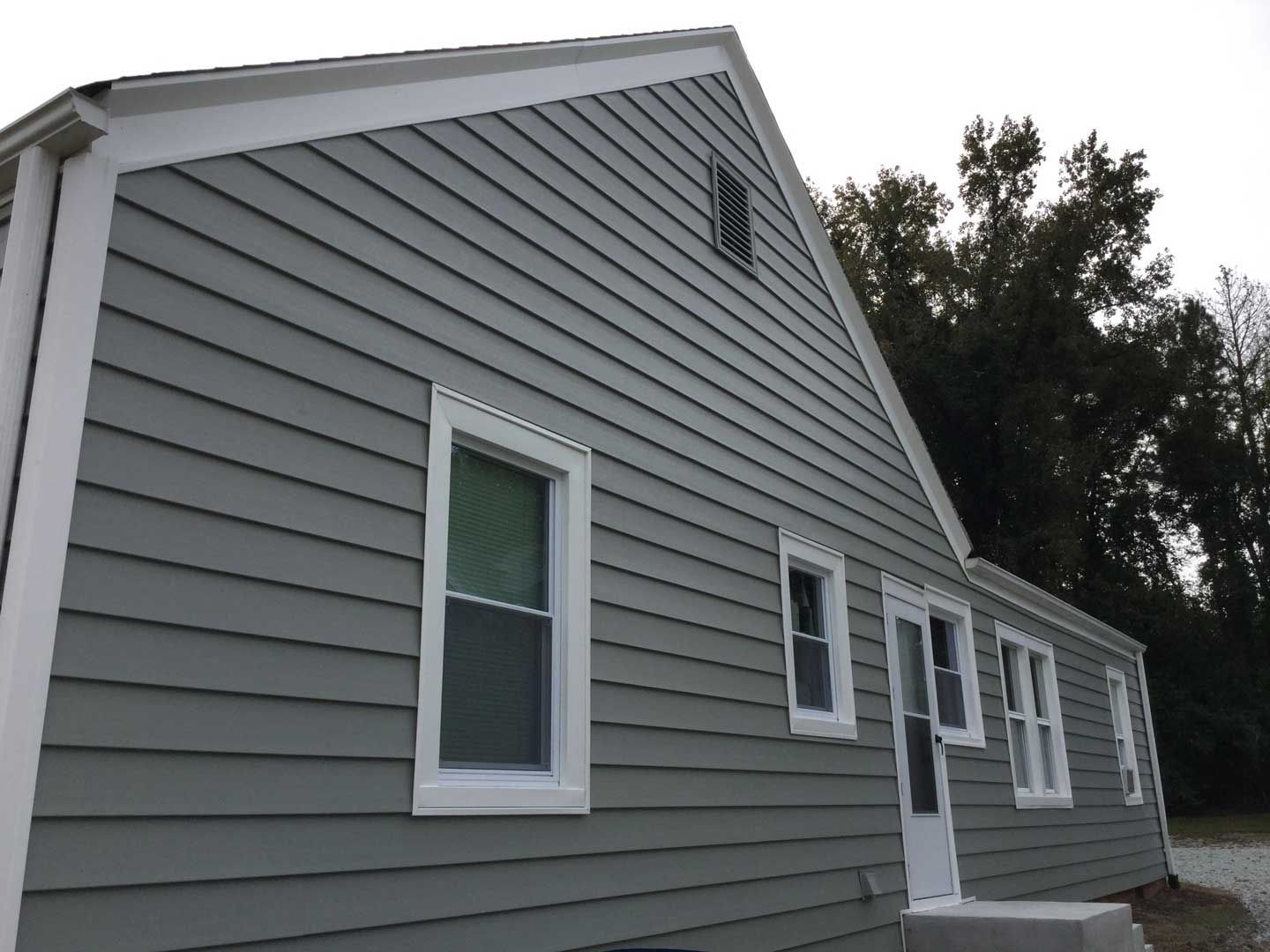 A house with a gray siding and white trim