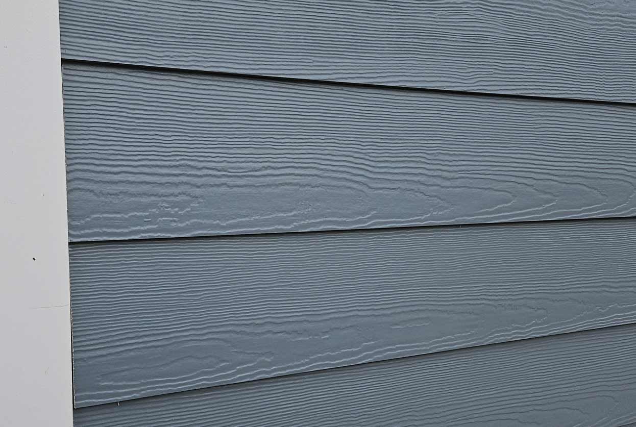 A close up of a blue siding on a house.