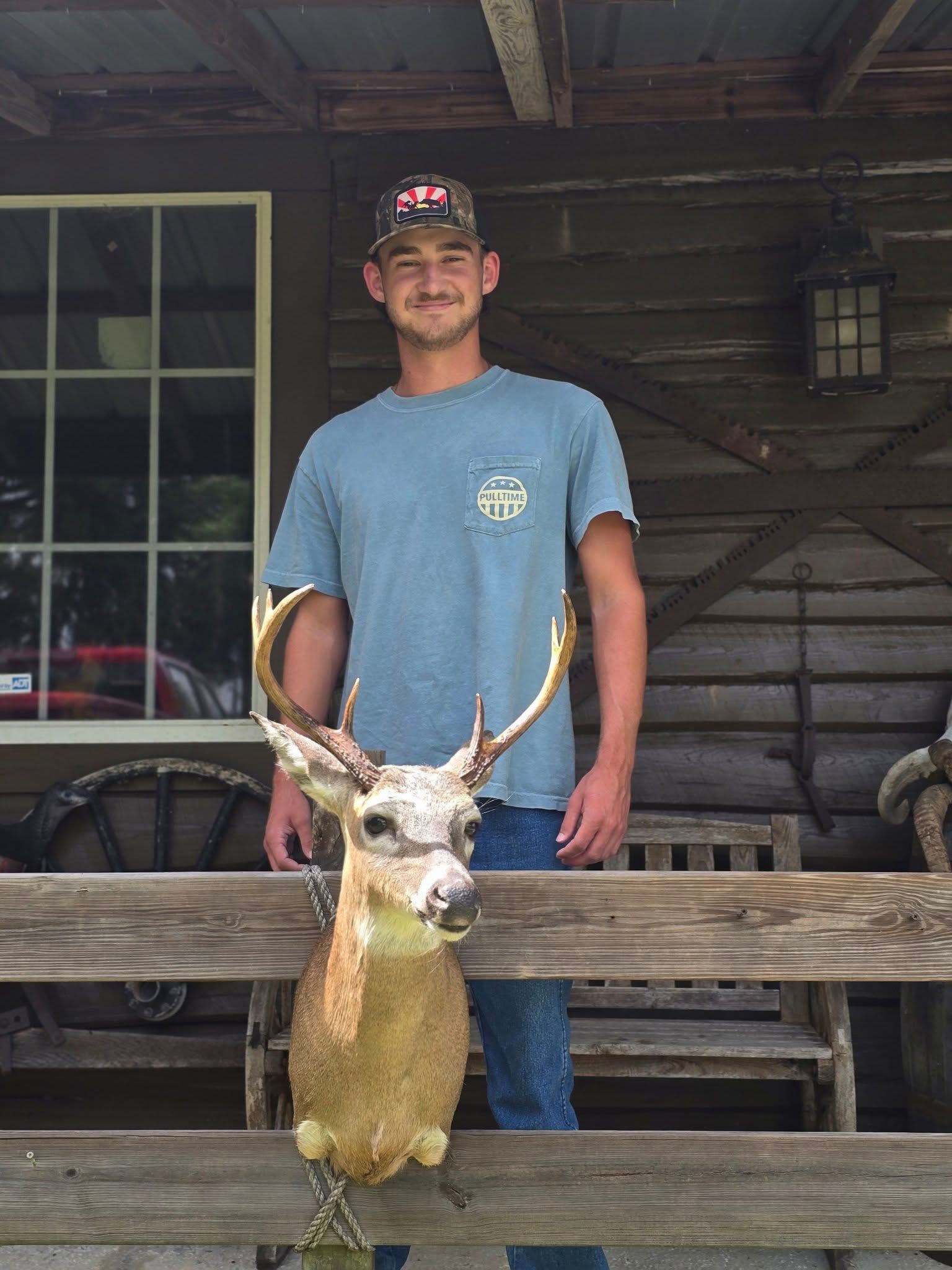 A taxidermized deer head and a man