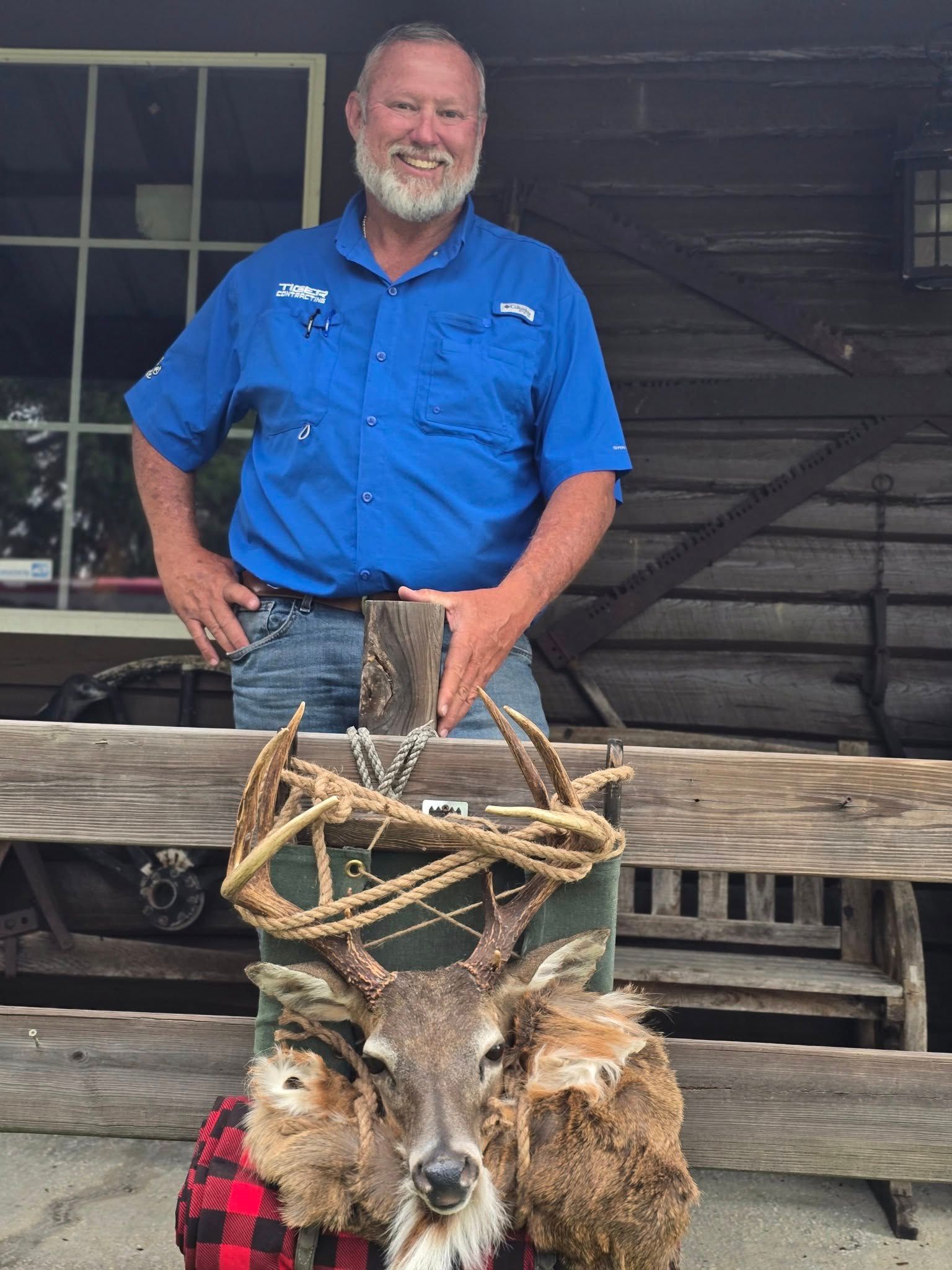 A taxidermized deer head and a man