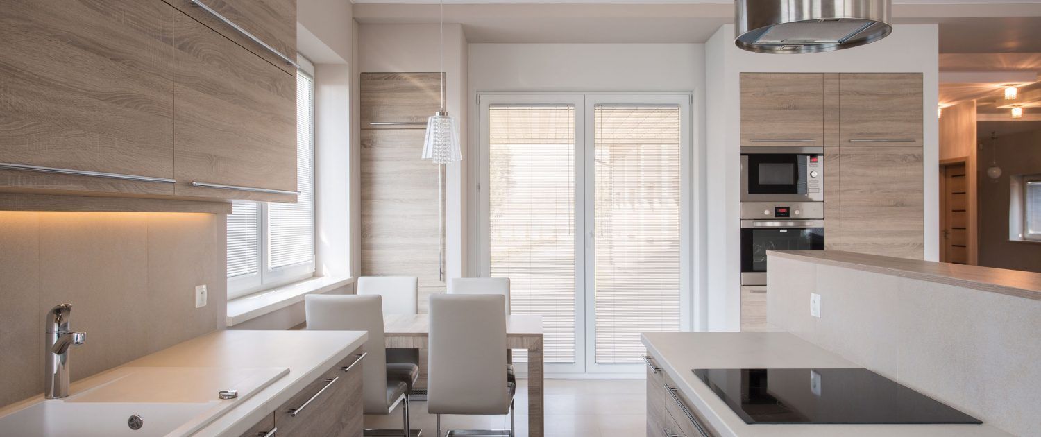 Modern open-plan kitchen and dining area with white cabinets, island, and sliding glass doors to a patio.
