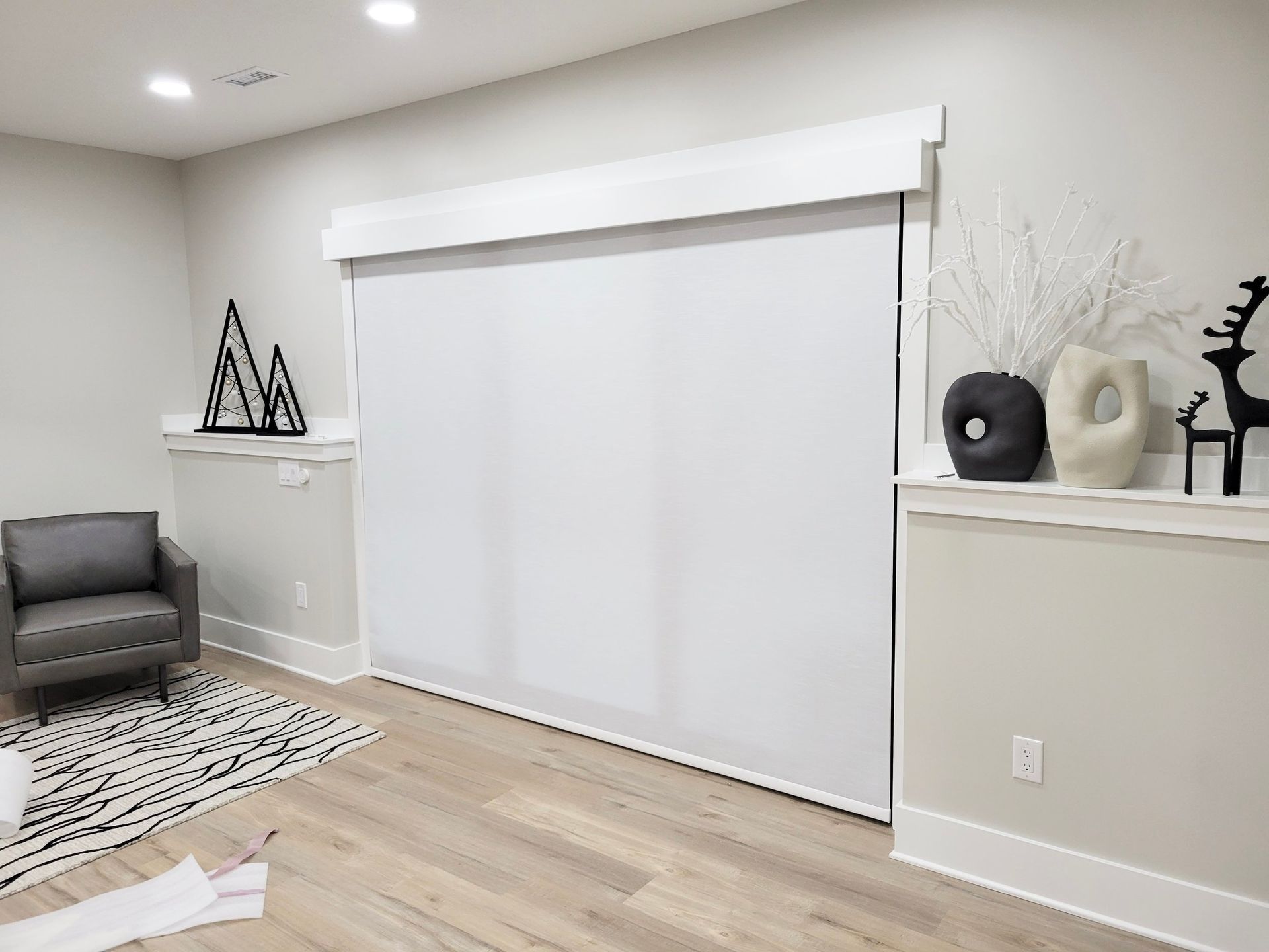 Interior room with a large white window shade and minimalist decor.
