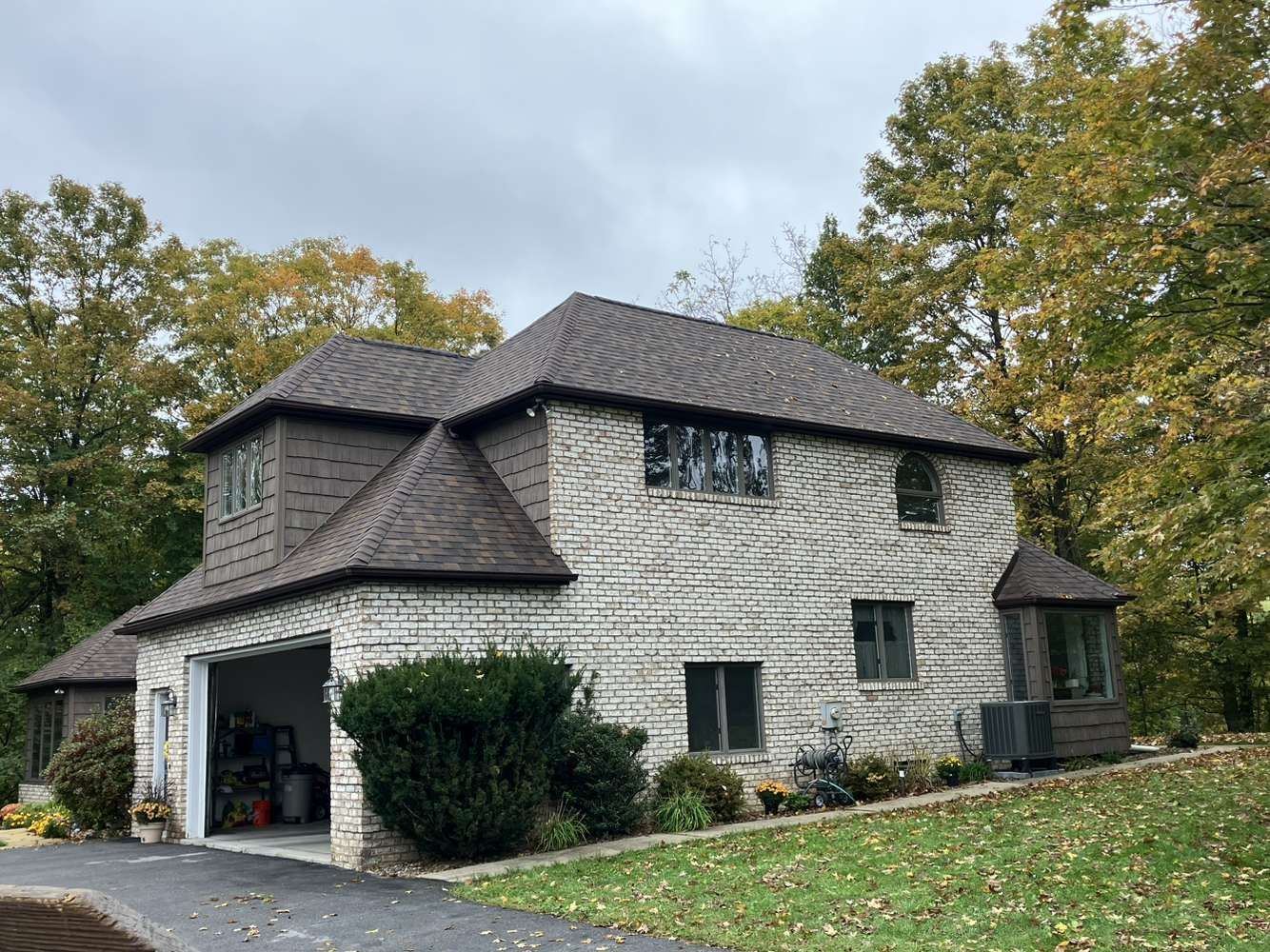 A large brick house with a garage and a bicycle parked in front of it.