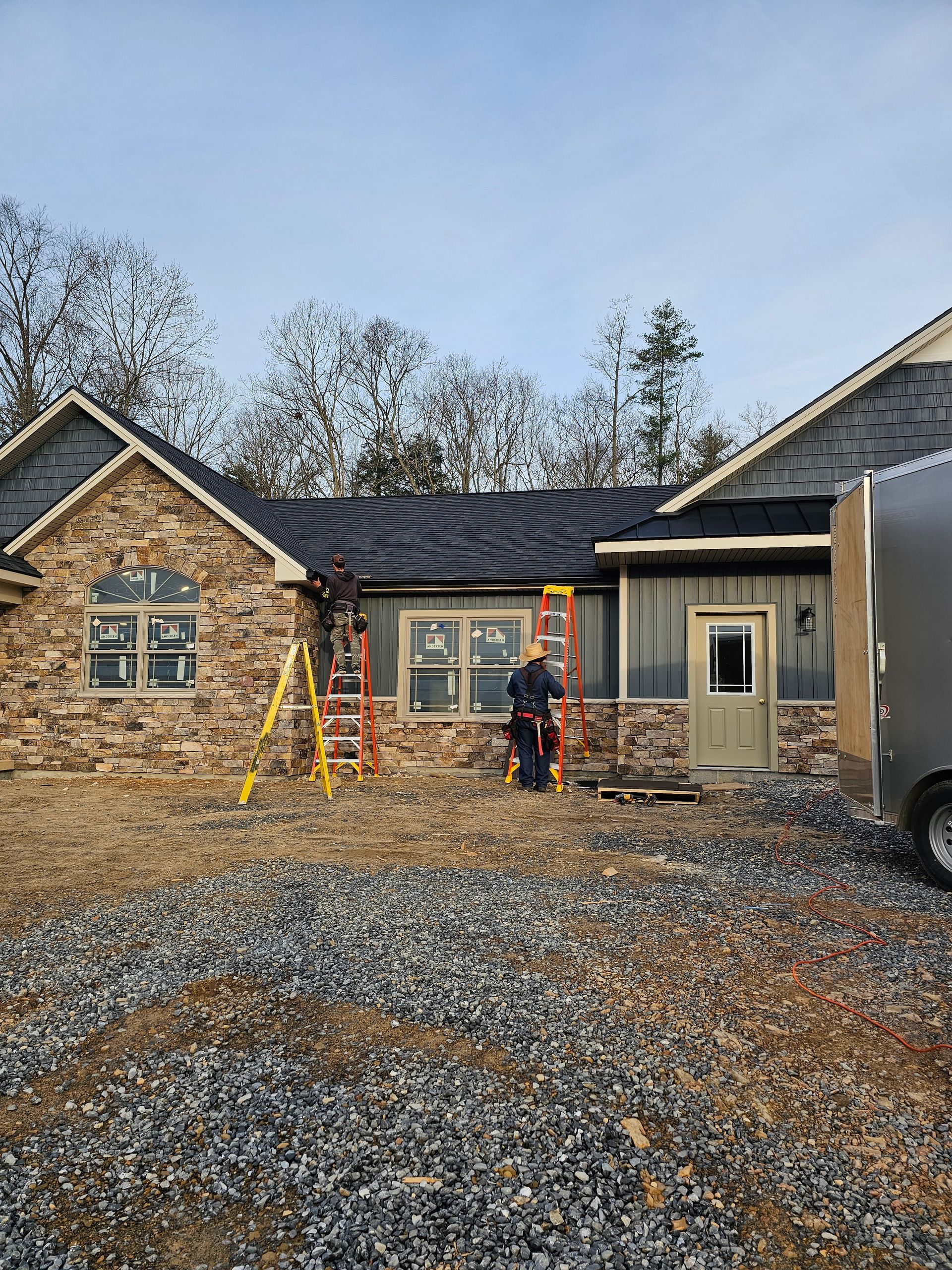 A man is standing in front of a house under construction.