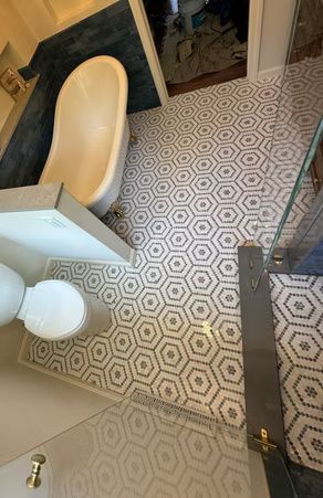 Bathroom with patterned tile floor, bathtub, toilet, and sink viewed from above