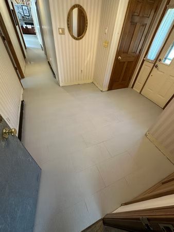 Small hallway with light tile floor, striped wallpaper, oval mirror, and several doors.