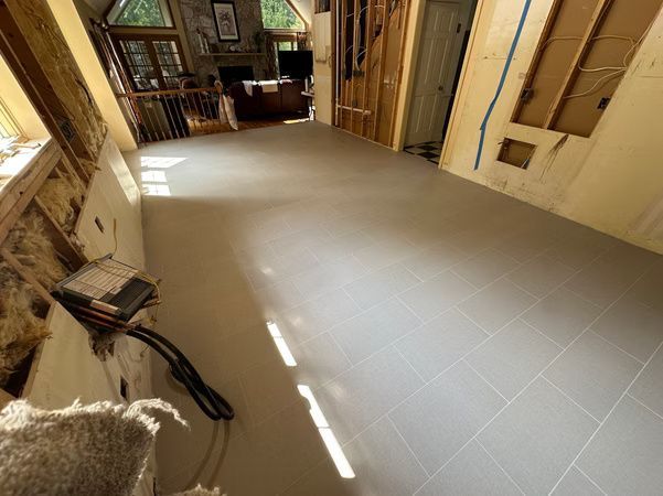 Empty tiled room with sunlight on the floor and wooden doors along the walls