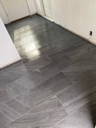 Empty hallway with dark gray tile floor and white walls