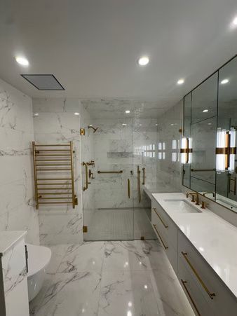 Modern marble bathroom with glass shower, double vanity, and wall-mounted towel rack