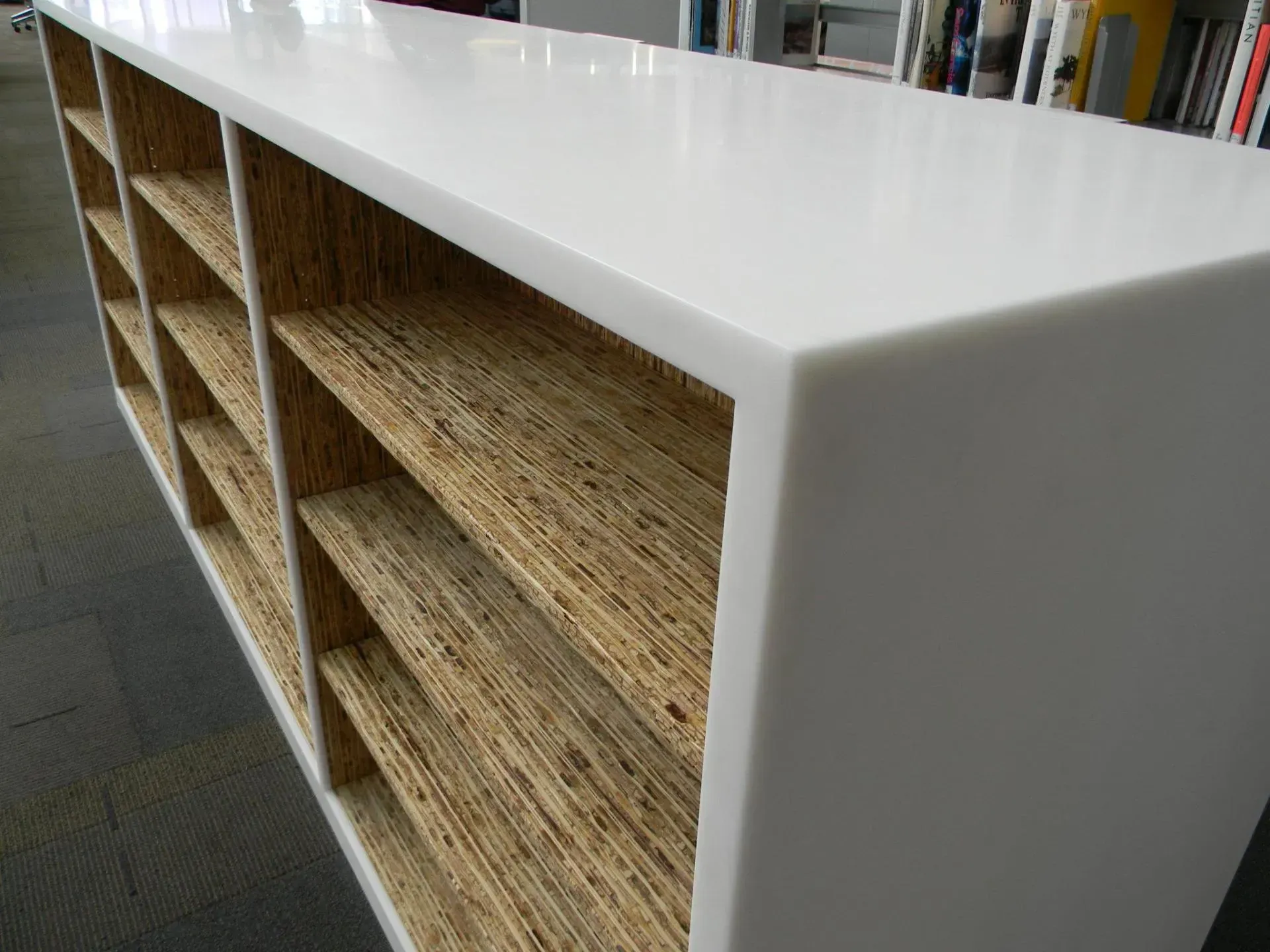 White shelving unit with woven basket-style cubbies in a store or library interior