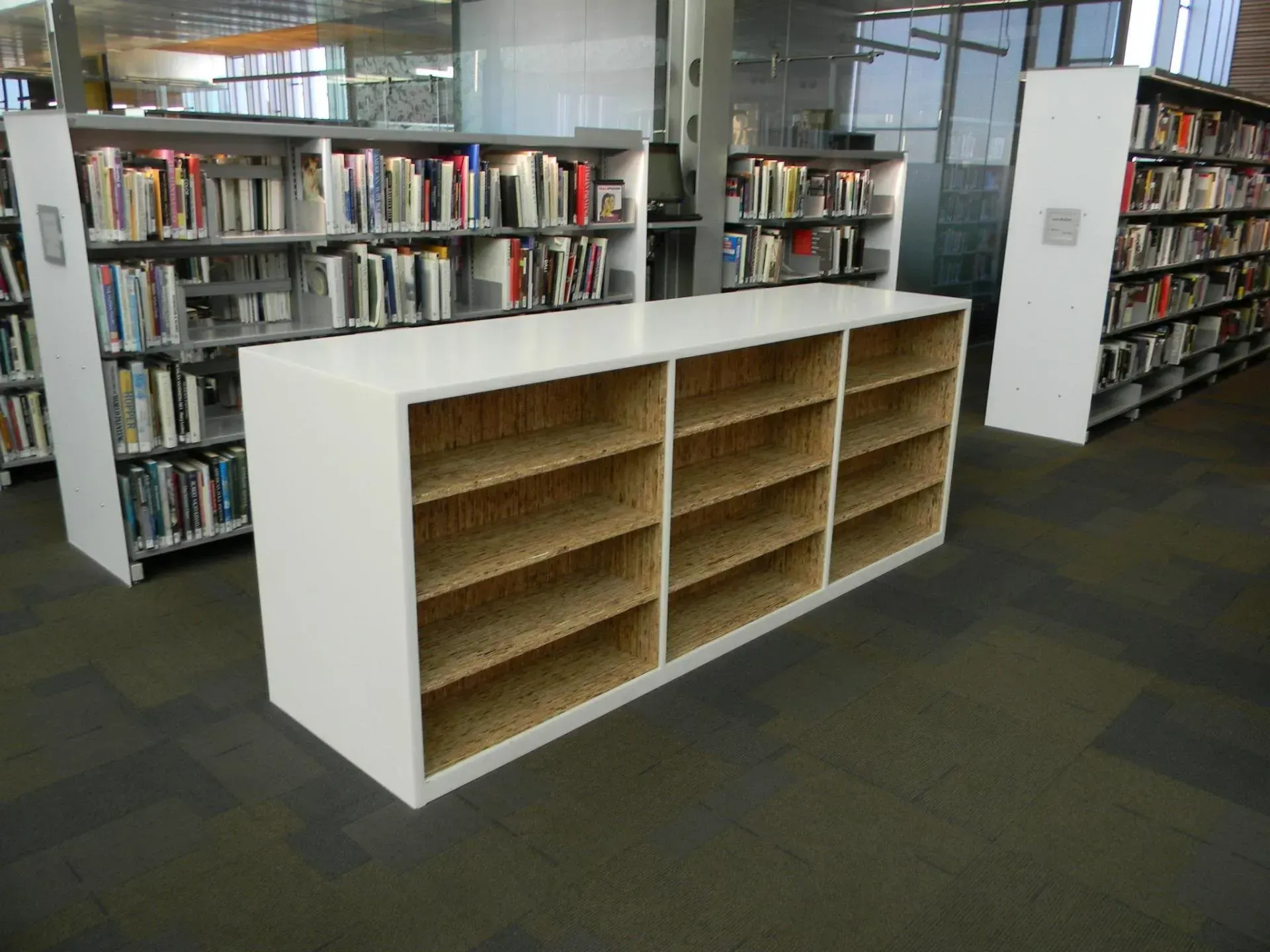 Library with white display shelves and rows of books in the background