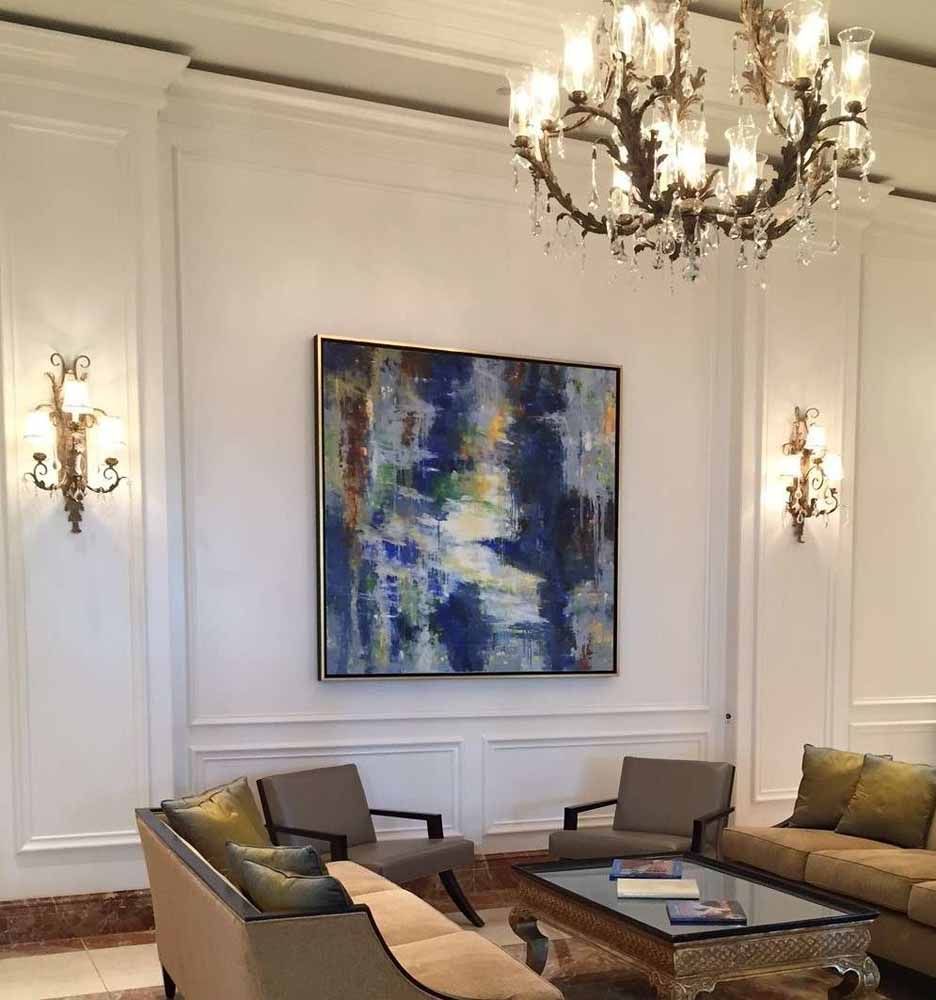 a living room with a chandelier and a painting on the wall