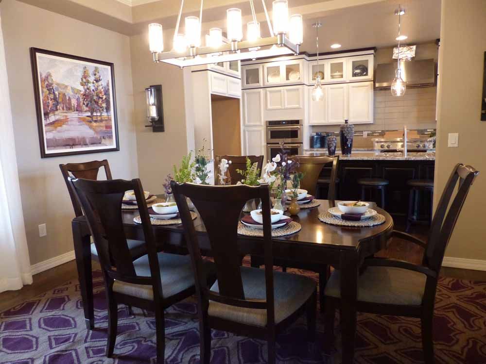a dining room with a table and chairs and a picture on the wall