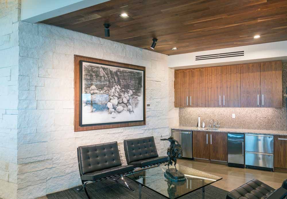 a living room with a painting on the wall and a glass coffee table