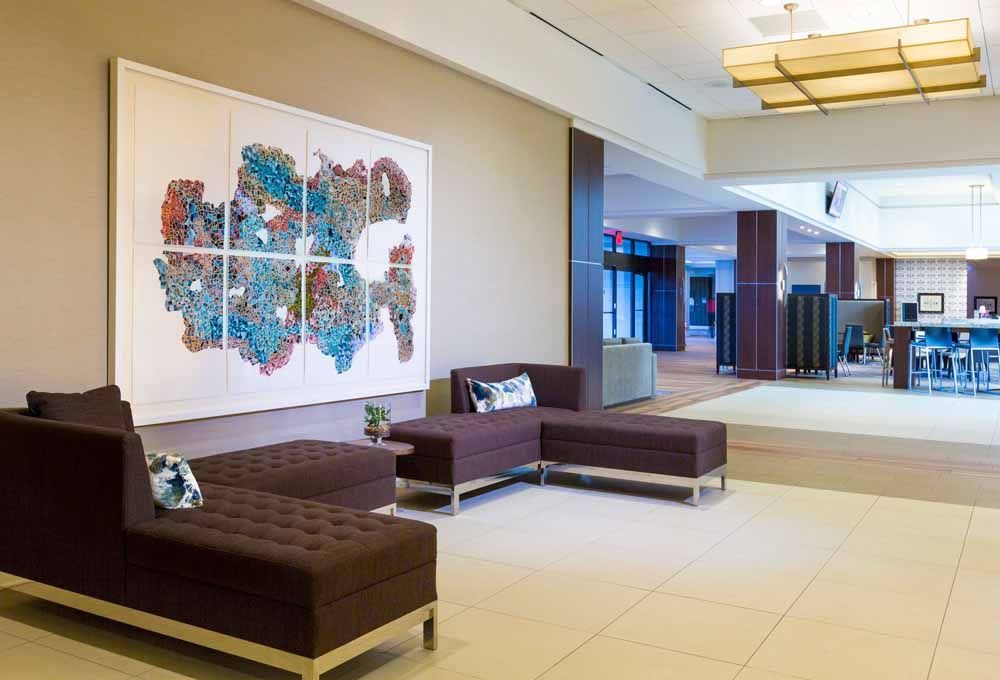 a lobby of a hotel with a couch and a painting on the wall