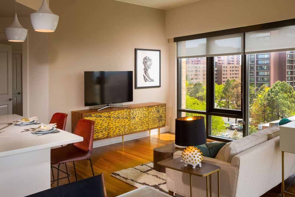 a living room with a couch , table , chairs and a flat screen tv