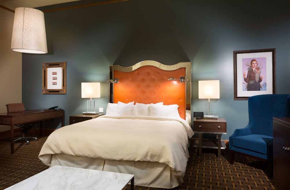 a hotel room with a king size bed and a chair