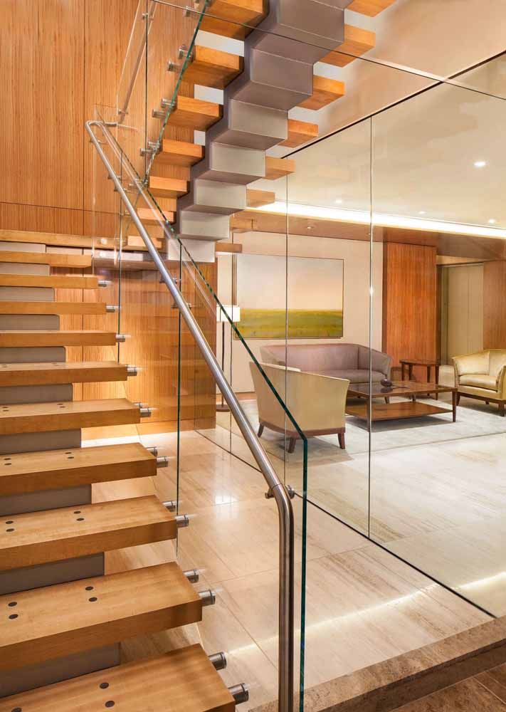 a wooden staircase with a glass railing in a living room