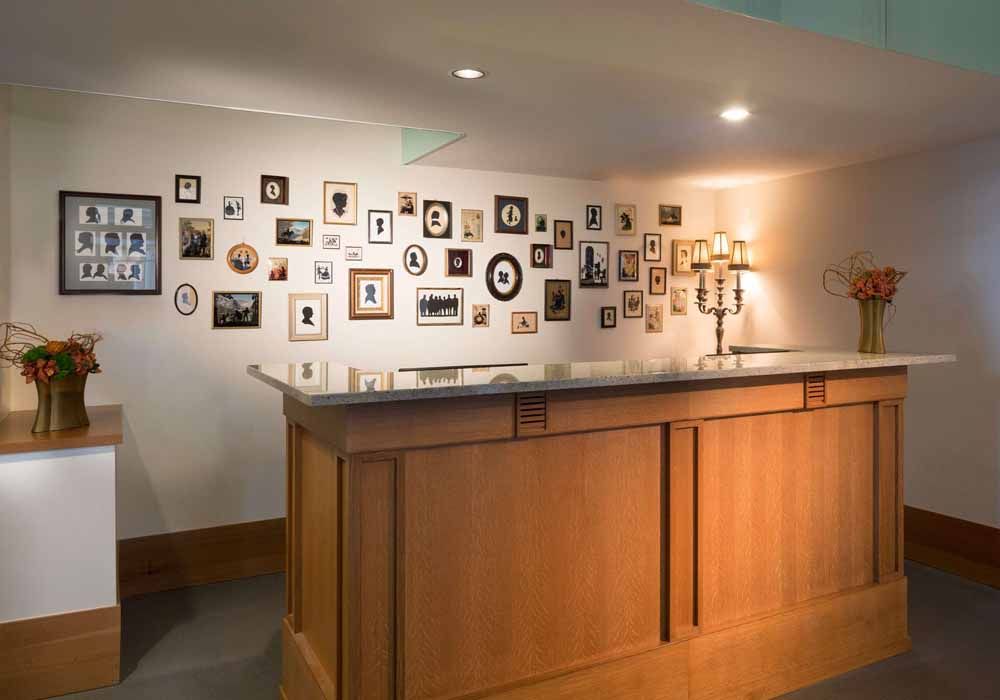 a wooden counter in front of a wall with pictures on it