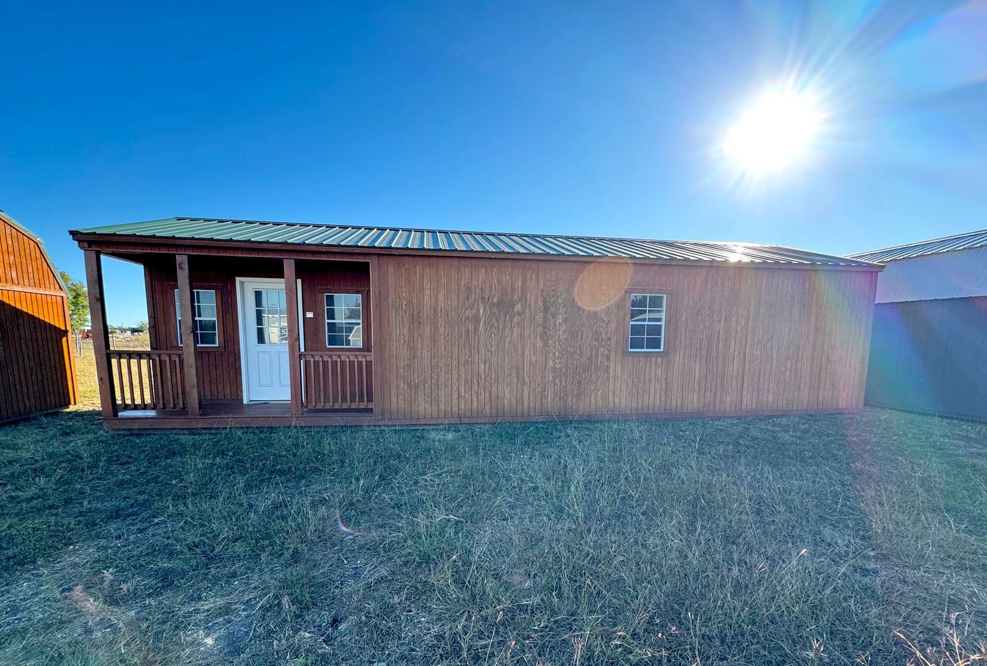 A wood-paneled portable cabin with a small front porch