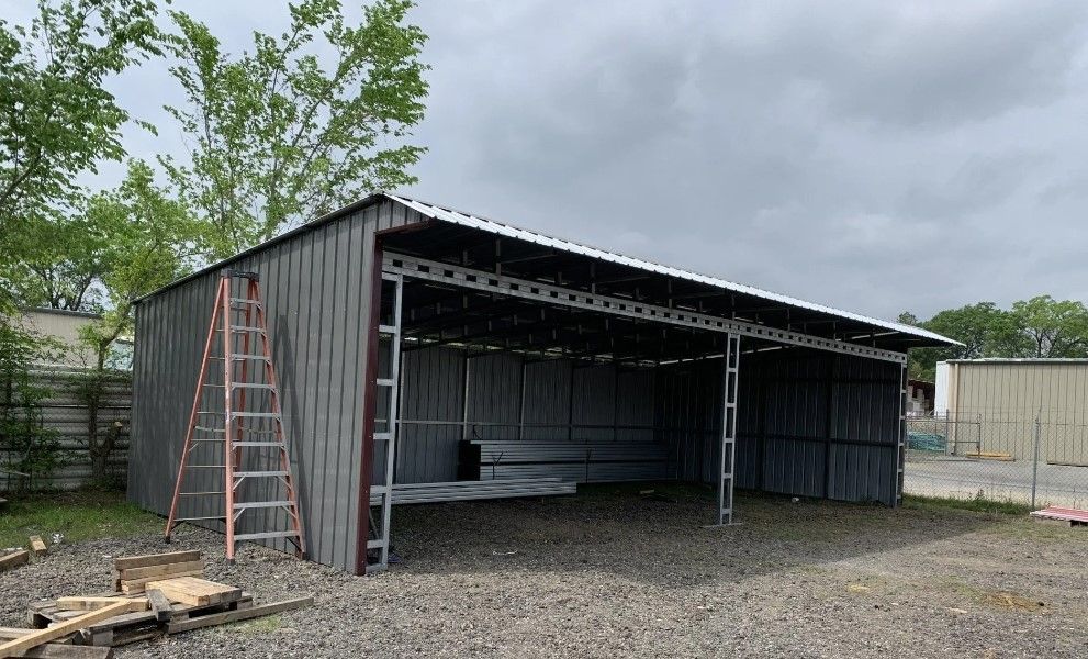 A metal building with a ladder in front of it is being built