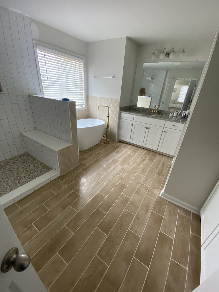 A bathroom with a tub, sink, and shower.