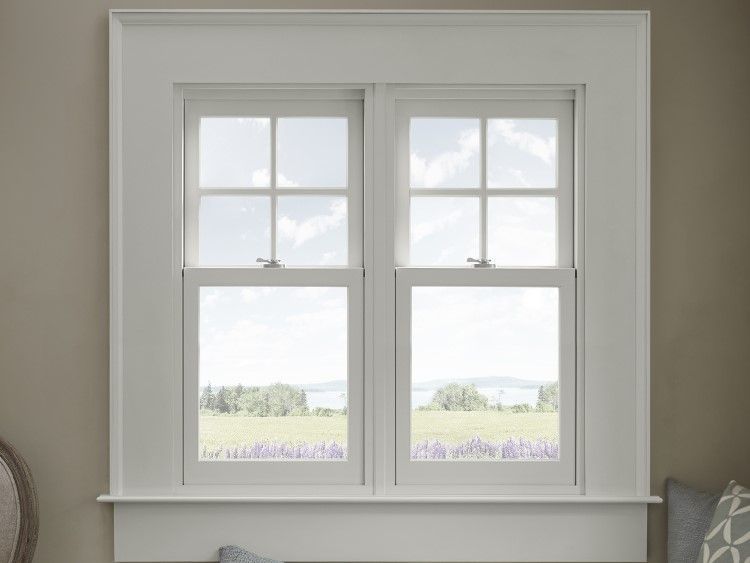 Double-hung window framed in white trim, looking out onto a landscape with a field of purple flowers.