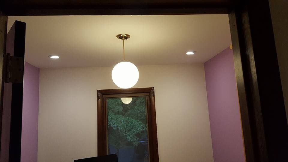 Interior room with a white globe light hanging from the ceiling and a window.