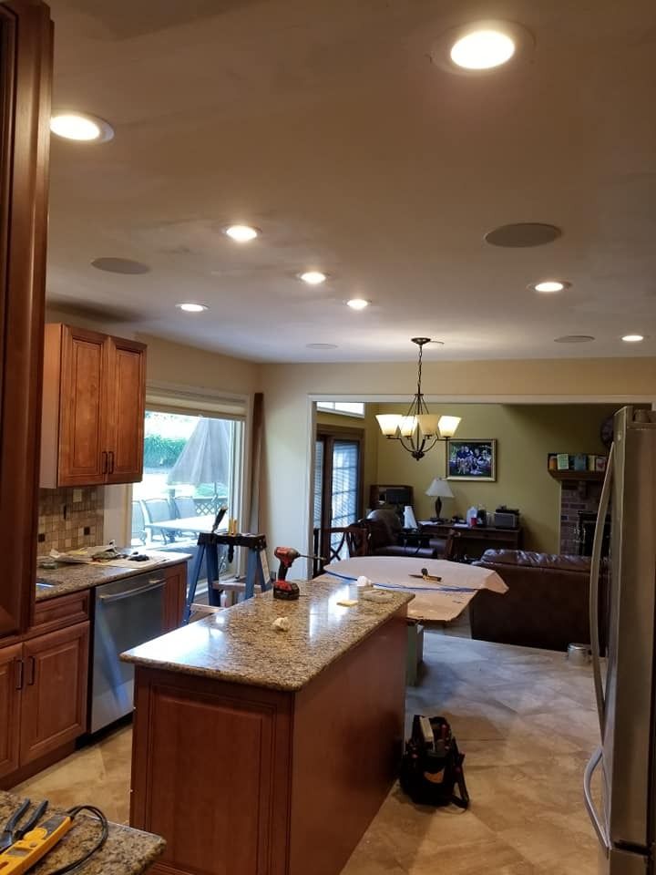 Kitchen renovation: Island with granite top, recessed lighting, and access to living room.