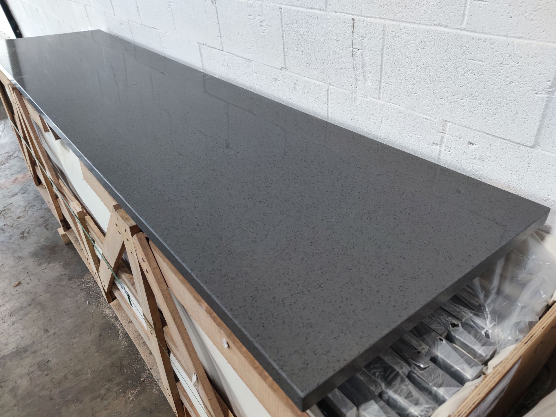 A long gray counter top is sitting on top of a wooden crate.