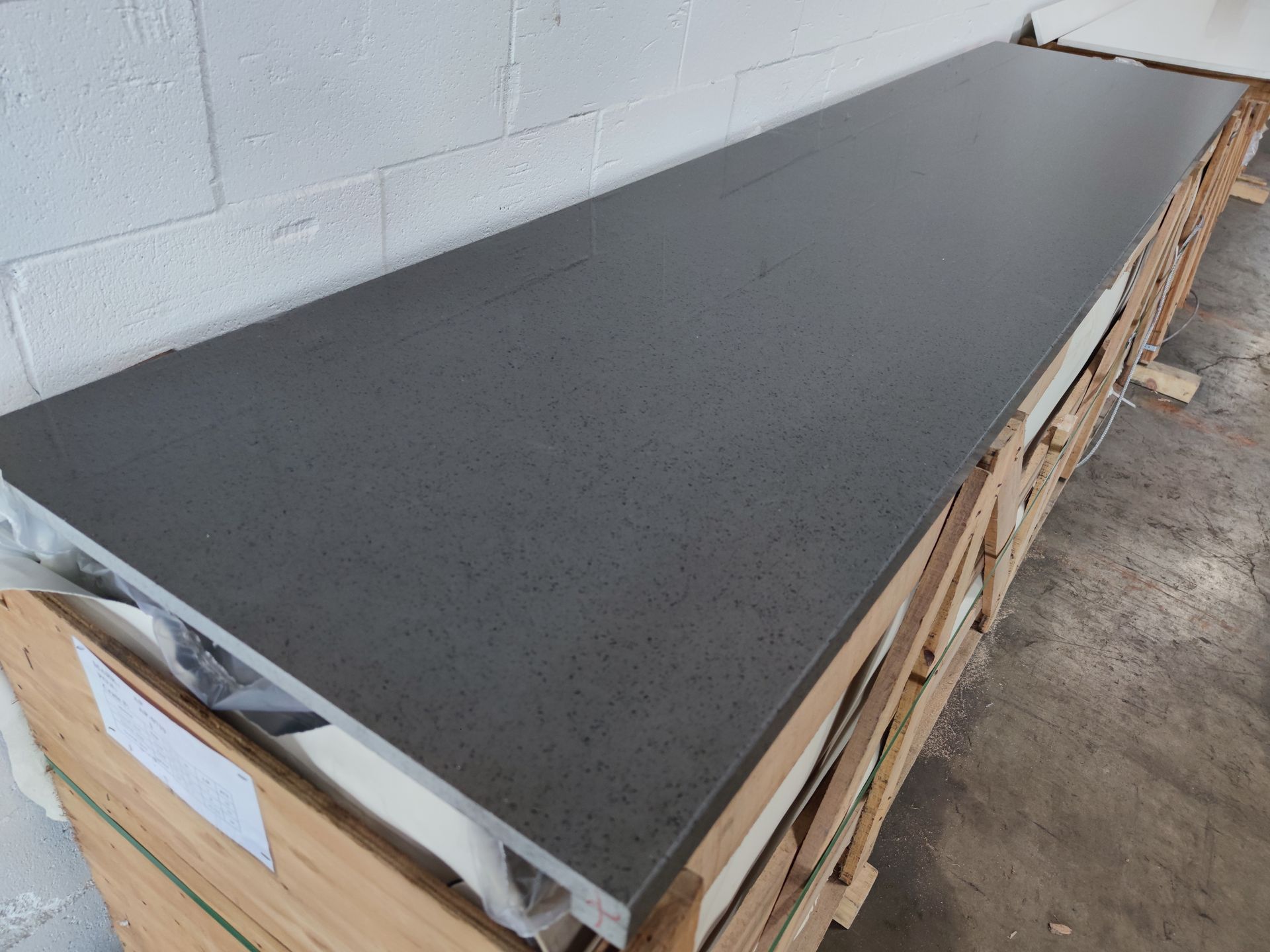 A black counter top is sitting on top of a wooden crate.